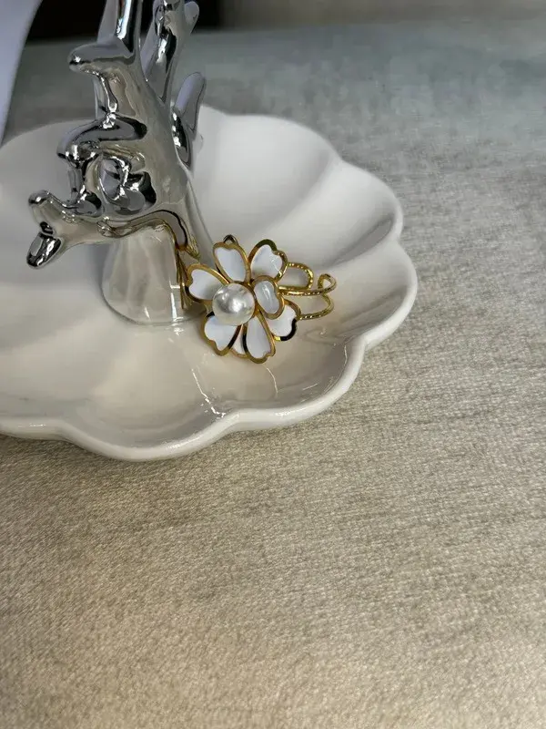 Flor de Perla — Flor esmaltada en blanco con perla en el centro.