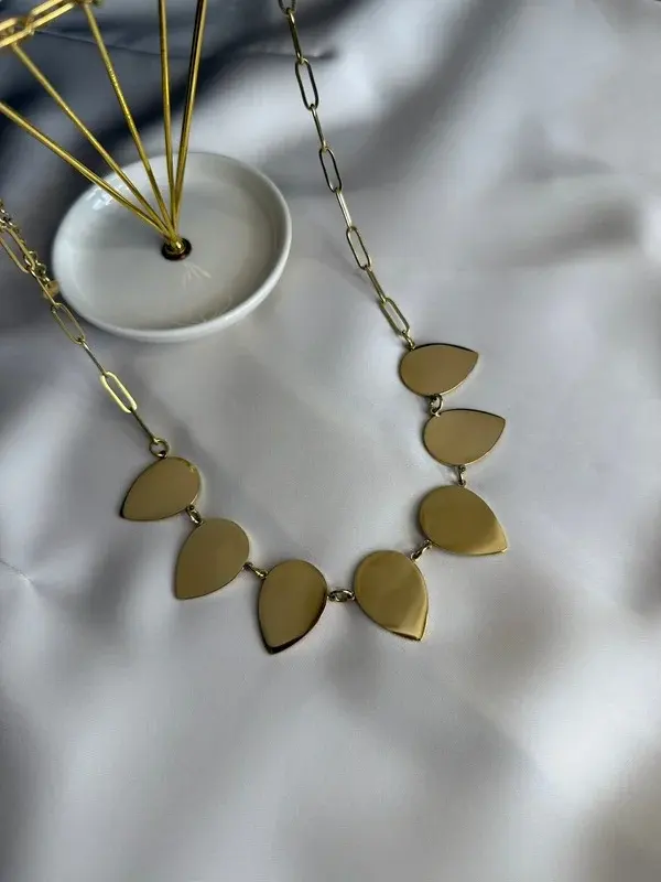 Pétalos — Cadena de eslabones con pétalos dorados.