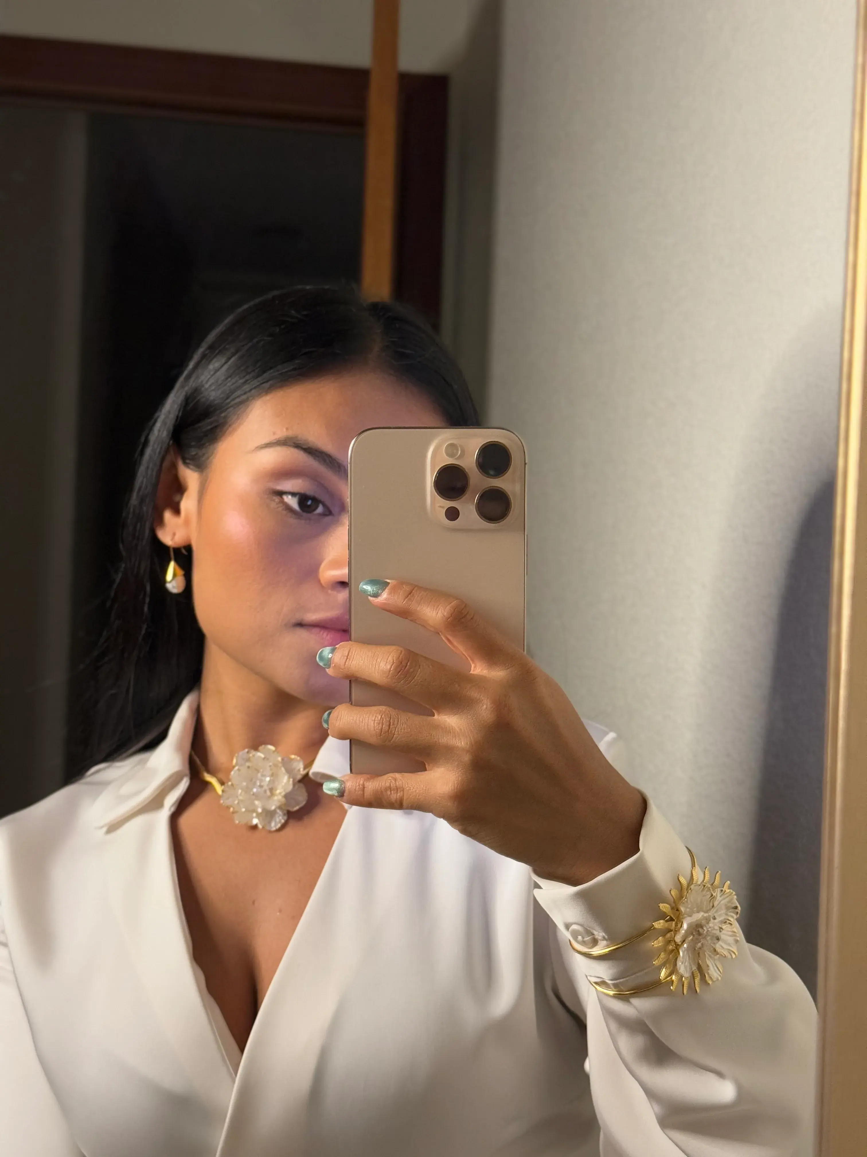 selfie de modelo con pendientes y collares de oro